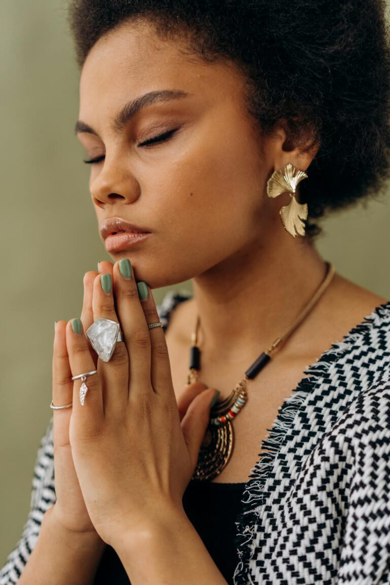 A woman with crystal accessories meditates, embodying calmness and spiritual focus.